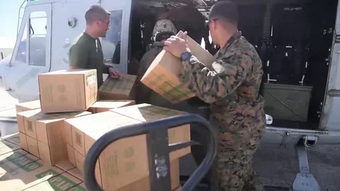 Marines loading boxes onto helicopter for hurricane relief Stock Footage 94060536