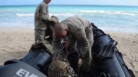 Marines loading inflatable craft with backpacks  Video stock 82934433