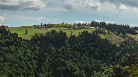 Marisel Timelapse- houses on a hill with forest below sunny day Stock Footage 131387356