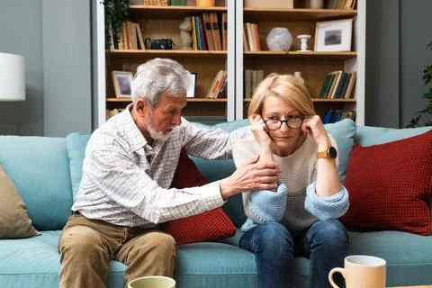 Marital problems and issues. Senior couple sitting at home and argue. Man o.. Stock Photos