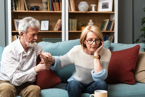 Marital problems and issues. Senior couple sitting at home and argue. Man o.. Stock Photos