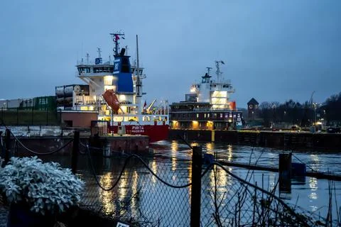 A maritime vessel in nighttime is entering the Kiel Canal from the Baltic Sea Stock Photos