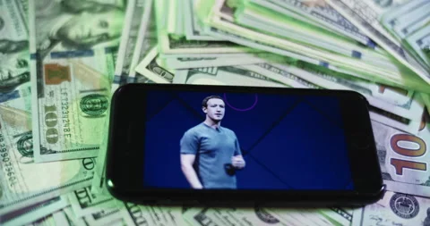 Mark Zuckerberg Image on iphone surrounded by $100 Bills. Stock Footage 169006069