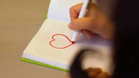 Marker draw a heart in a notebook 4K Stock Footage 102635748