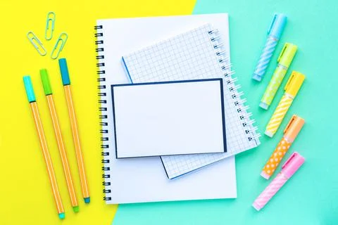Markers and markers around of stack of notebooks on a spiral overlap. Stock Photos