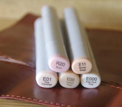 Markers lying on a brown leather notebook cover background. Foto stock
