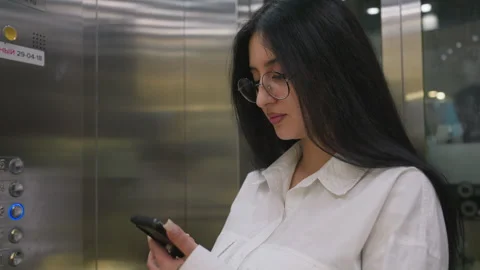 Marketer chatting on phone inside modern elevator Vídeos de archivo 310142778