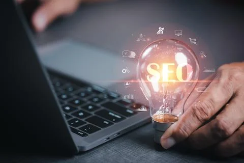 Marketer hold a light bulb showing SEO concepts, optimization analytics too.. Stock Photos
