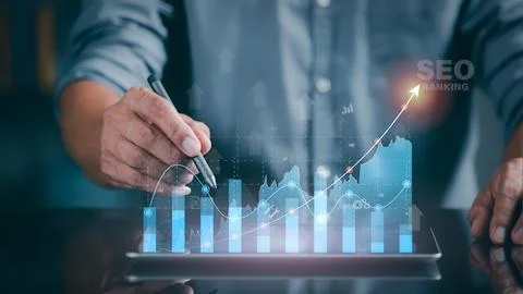 A marketer holds a pen pointing to a graph and shows SEO concepts, optimiza.. Stock Photos
