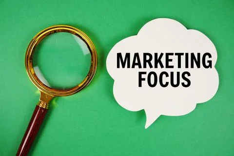 Marketing Focus text with speech bubble and magnifying glass on green backg.. Stock Photos