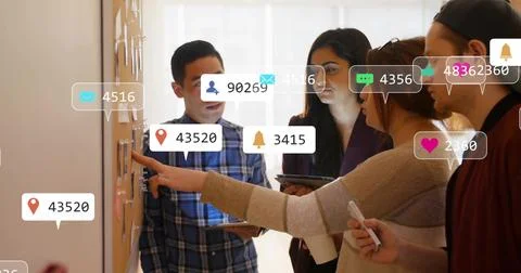 Marketing team pointing at board while icons flowing from left responding and Stock Photos