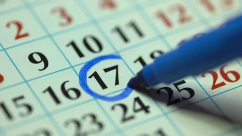 Marking the date in the calendar with a blue marker Stock Footage 121903612
