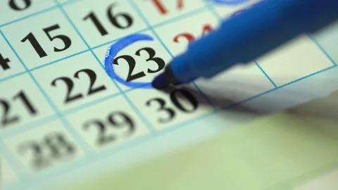 Marking the date in the calendar with a blue marker. The twenty-third day Stock Footage 122661910