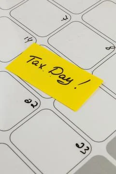 Marking an important date with a sticky note for tax day reminders Stock Photos