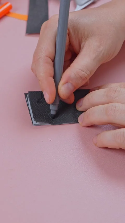 Marking a stencil pattern on folded black paper before cutting it out Stock Footage 347034288