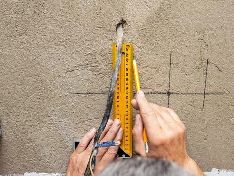 Markings for sockets on the wall, a man is installing sockets in the wall Stock Photos