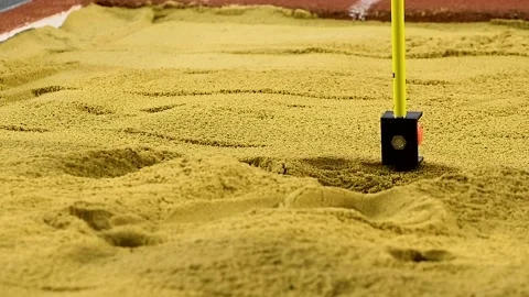 The marks on the sand are used to measure the length of the jump using a sp.. Видео 339766420