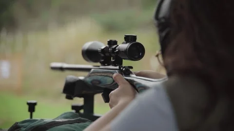 Marksman looking through rifle telescopic sight preparing to pull trigger Video stock 256056006