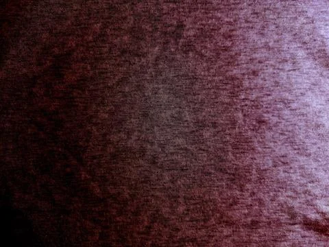 Maroon heather fabric texture with dramatic side lighting creating mysterious Foto stock