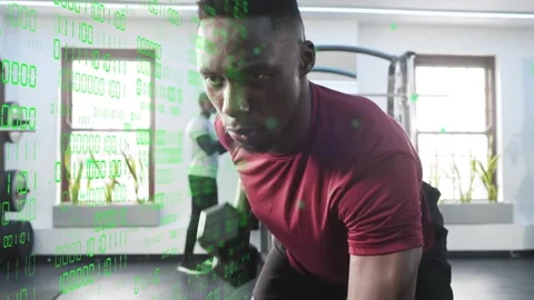 Maroon-shirt lifter doing rows, gripping weight for fitness, green binary Stock Footage 334203495