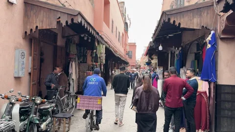 The Marrakech Medina with people walking through the souk among shops Stock Footage 339649327