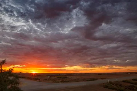 Marree crossroads with dramatic clouds sunset and copy space, Marree,Australia Stock Photos