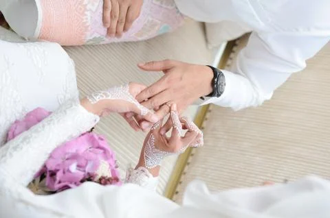 Marriage hands with rings. birde wears the ring on the finger of the groom Stock Photos