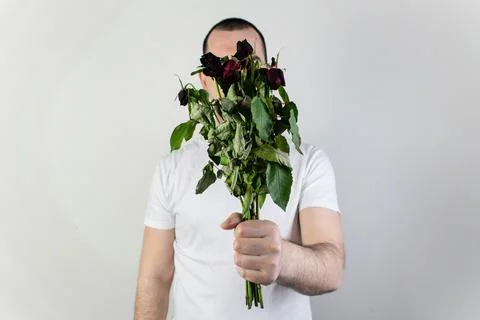 Marridge problems, man hold old dead flowers couples divorce depression rose Stock Photos
