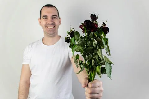 Marridge problems, man hold old dead flowers couples divorce depression rose Stock Photos