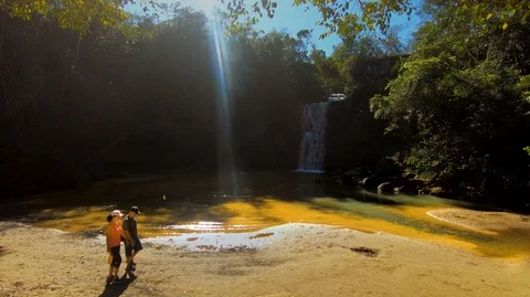 Married athletic couple walking in front of Waterfall Stock Footage 115092407