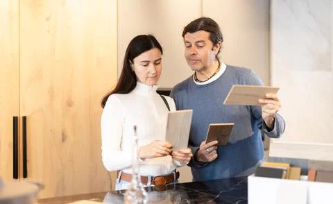 Married couple choosing samples for kitchen decoration Stock Photos