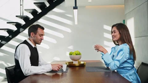 Married couple drinking coffee early in the morning at the table in the kitchen Stock-Footage 205325282