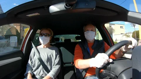 Married Couple with Face Covered by Protective Masks Driving Car to Grocery Shop Stockbeeldmateriaal 129254151