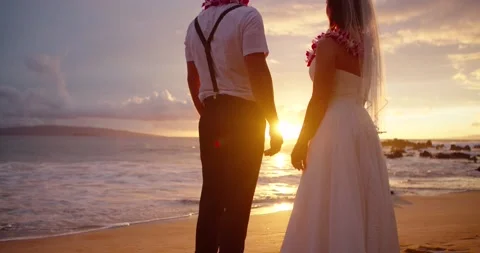 Married couple hold hands during golden hour sunset on tropical Maui. Stock Footage 134844711