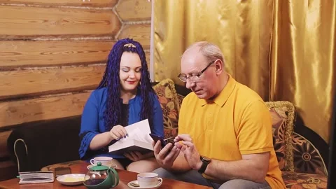 A married couple at home on the sofa at a small table, a man and a woman with an Vidéo 146707870