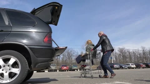 Married couple loading purchases in a car Stock Footage 133517489