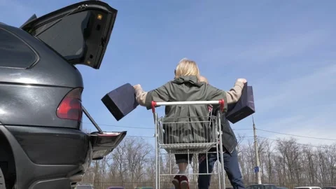 Married couple loading purchases in a car Stock Footage 133518981