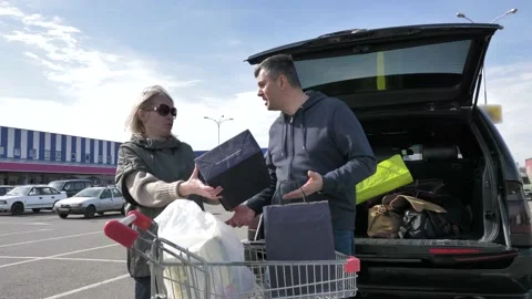 Married couple loading purchases in a car Stock Footage 133523689