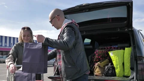Married couple loading purchases in a car Stock Footage 133526829