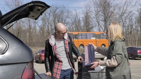 Married couple loading purchases in a car Stock Footage 133527097