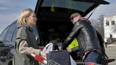 Married couple loading purchases in a car Stock Footage 133528147