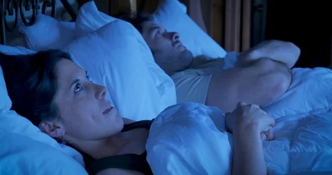 Married couple lying in bed angry at each other at night Video stock 108329502