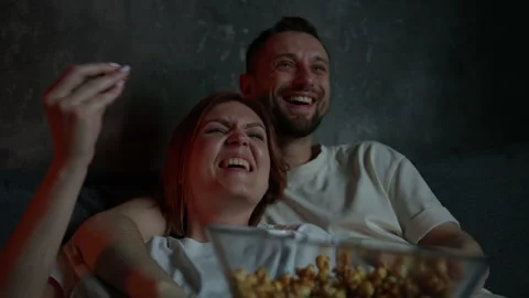 Married couple lying on the couch and watching a movie. Family evening Stock Footage 258891891