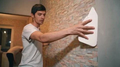 A married couple makes repairs in their home, neatly gluing wallpaper, Vidéo 146041534