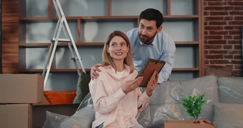 Married Couple preparing for Moving sitting on sofa while Couriers take away Video stock 172080625