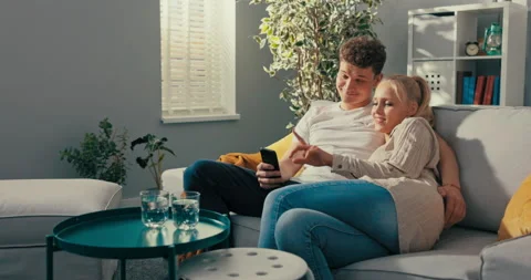 A married couple relaxes after work on the couch in the living room of their Stockbeeldmateriaal 161735518
