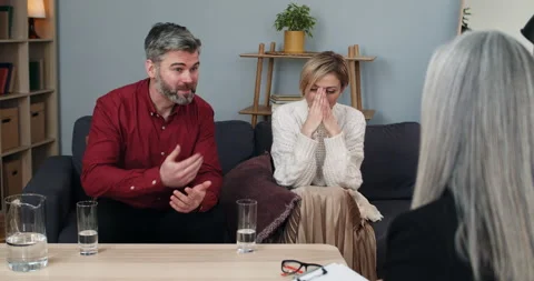 Married couple sharing family problems while sitting in front of psychologist Stock Footage 152360253