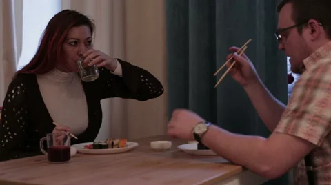Married couple sitting at the table eating sushi Stock Footage 58801341