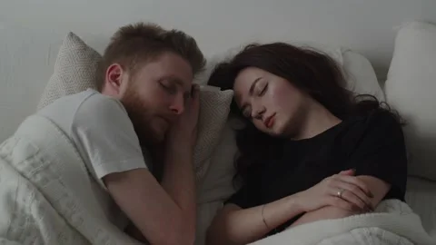 Married couple sleeping in bed next to each other. Video of young woman and Stock Footage 233968515
