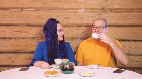 A married couple at the table at home a man and a woman with an Afro-hair drink Stock Footage 146060245